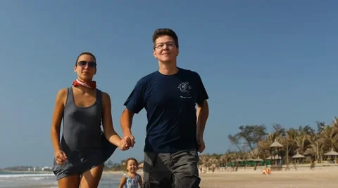 Young couple having fun on the beach.Cute child running for parents.slow motion. Video stock 50605737