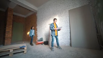 Young couple having fun doing repairs in the apartment. The girl sat on his back Stock-Footage 86080914