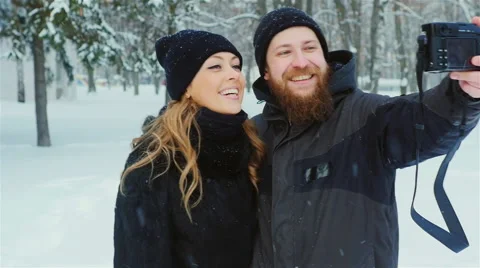Young couple having fun in the forest - do selfie in snow Stock Footage 65890558