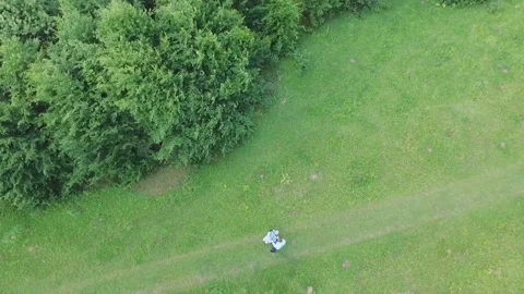 Young couple having fun on the green field in the spring or summer, general plan Stock Footage 85688817