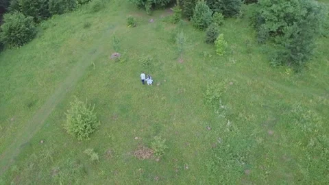 Young couple having fun on the green field in the spring or summer, general plan Stock Footage 85691073