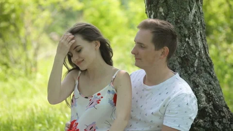 Young couple having fun on the green field in the spring or summer, general plan Stock Footage 85876174
