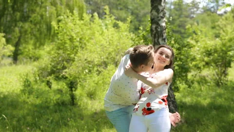 Young couple having fun on the green field in the spring or summer, general plan Stock Footage 85937137