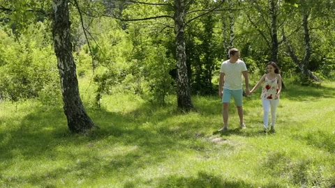 Young couple having fun on the green field in the spring or summer, general plan Stock Footage 85938305