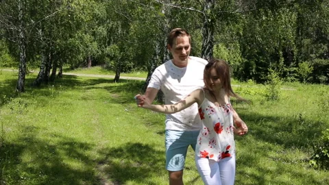 Young couple having fun on the green field in the spring or summer, general plan Stock Footage 85939212