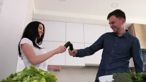 Young couple having fun in the modern kitchen.Vegetables in the foreground. Video stock 131220879