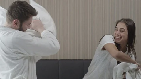 Young couple having fun with pillows in bedroom Stock Footage 73349255