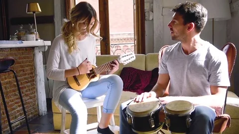 Young couple having fun playing musical instruments Stock Footage 74729782