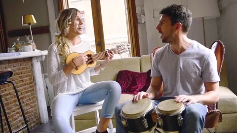 Young couple having fun playing musical instruments Stock Footage 74729836