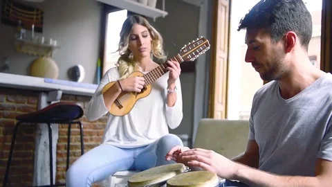 Young couple having fun playing musical instruments Stock Footage 74729851