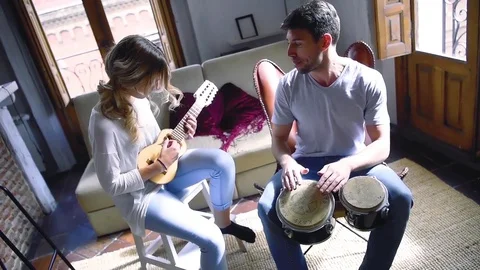 Young couple having fun playing musical instruments Stock Footage 74729865