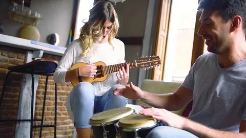 Young couple having fun playing musical instruments Stock Footage 74729873