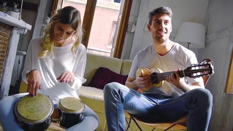 Young couple having fun playing musical instruments Stock Footage 74729892