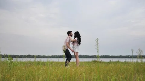 Young couple having fun on a romantic date outdoors, by the river. A beautiful Stock Footage 208692797