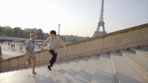Young couple having fun running up the stairs at the Tour Eiffel in Paris Stock Footage 96384511