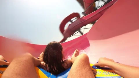 Young Couple Having Fun Sliding Down in a Water Slide Waterpark Stock Footage 158799444