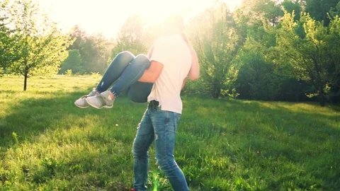 Young couple having fun in spring park. Guy twirling girl on hands. Stock Footage 89520940