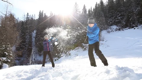 Young couple having fun together playing snowballs, winter activities in snow Stock Footage 98099504