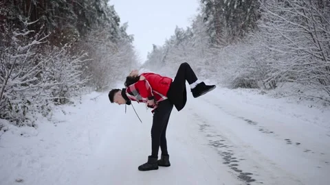 Young couple having fun while walking in a snowy forest Stock Footage 257816480