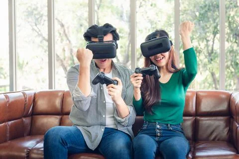 Young Couple Having Fun While Playing Virtual Reality Game Together Stock Photos