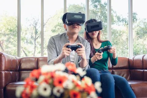 Young Couple Having Fun While Playing Virtual Reality Game Together Foto stock