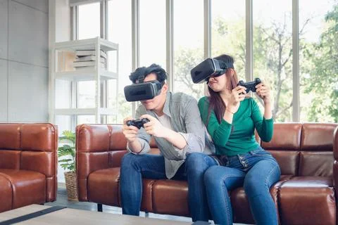 Young Couple Having Fun While Playing Virtual Reality Game Together Stock Photos