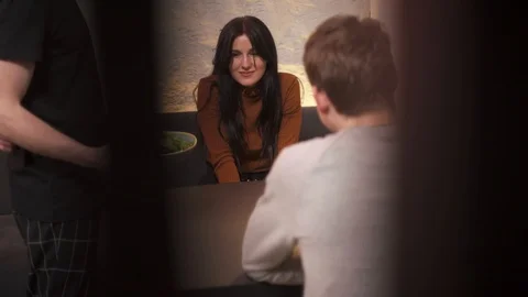 Young couple having lunch at a bar. The waiter brings the client a salad. Stock Footage 102760208