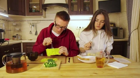 Young couple having lunch from plastic containers in the kitchen Stock-Footage 150223554