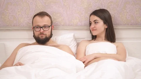 Young couple having problems in bed, a girl lifts a blanket and unpleasantly Video stock 102398793