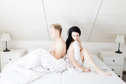 Young couple having problems in bed. Man and woman bother during intimate mom Stock Photos