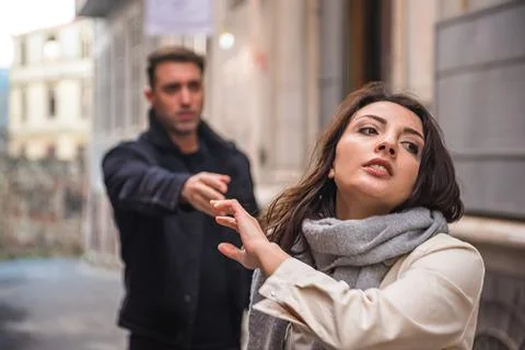 Young couple having relationships problems at street. Stock Photos