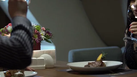 Young couple having romantic date in restaurant. Close-up of wine glasses. Stock Footage 83665859