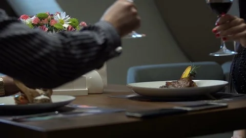 Young couple having romantic date in restaurant. Close-up of wine glasses. Stock Footage 83665948