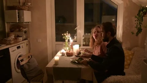Young couple having a romantic dinner together at home by candlelight. 库存影片 330804839