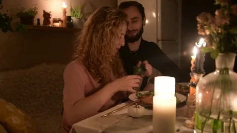 Young couple having a romantic dinner together at home by candlelight. 库存影片 330805053