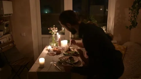 Young couple having a romantic dinner together at home by candlelight. 库存影片 330805094