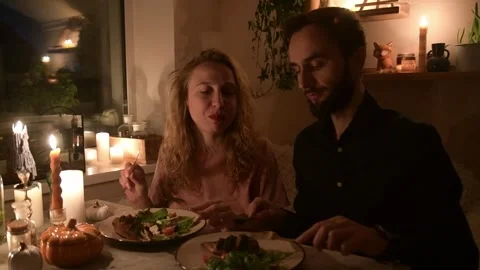 Young couple having a romantic dinner together at home by candlelight. Vídeo Stock 330805105