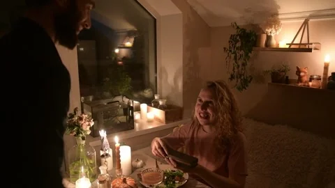 Young couple having a romantic dinner together at home by candlelight. Vídeo Stock 330805453