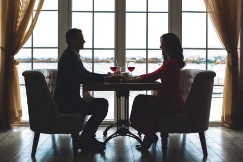 Young couple having romantic dinner in the restaurant holding hands Stock Photos