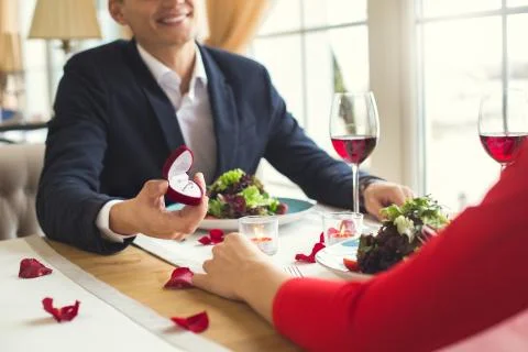 Young couple having romantic dinner in the restaurant proposal ring close-up Stock Photos