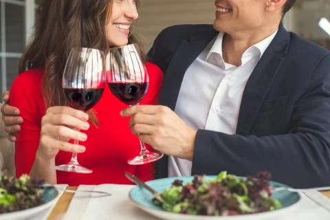 Young couple having romantic dinner in the restaurant cheers close-up Stock Photos