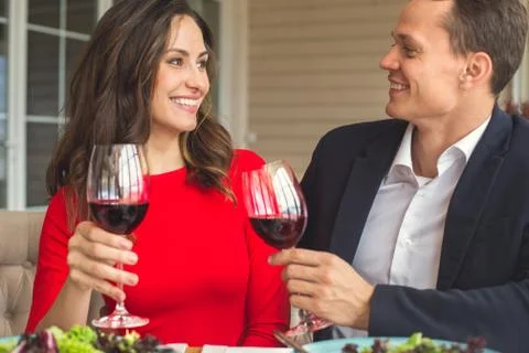 Young couple having romantic dinner in the restaurant cheers Stock Photos