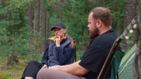 Young couple having serious conversation while camping in a forest Stock Footage 327135010