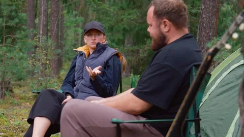 Young couple having serious conversation while camping in a forest Stock Footage 327135074