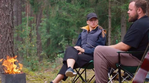 Young couple having serious conversation while camping in a forest Stock Footage 327135124