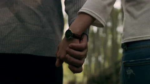 Young couple holding hands and walking through a pathway in a bamboo forest in K Stock Footage 199459139
