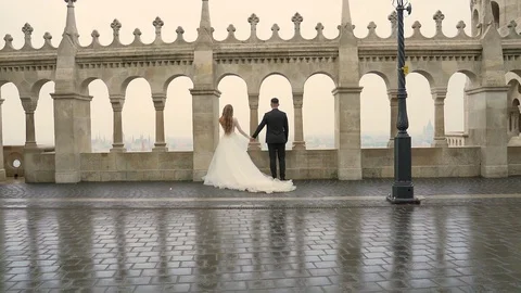 Young couple holding hands go together architecture of old castle and city. on t Stock Footage 129508225