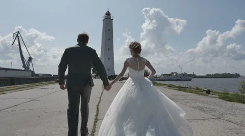 A young couple holding hands going to the lighthouse. romantic love Russia Stock Footage 64810204
