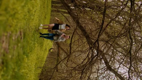 A young couple holding hands run through the forest, embodying an active lifesty Stock Footage 271556645