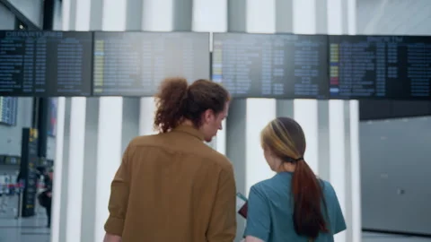 Young couple holding hands walking through airport terminal Video stock 334562223